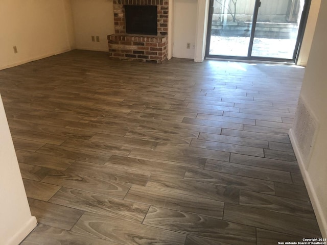 unfurnished living room with a fireplace and dark hardwood / wood-style flooring