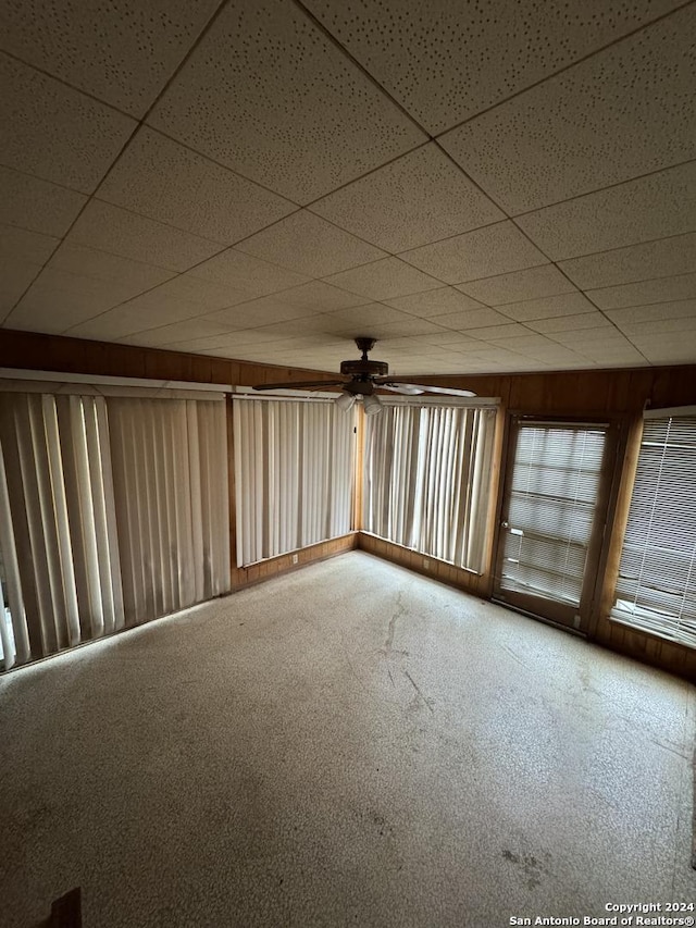 unfurnished room with carpet flooring, ceiling fan, and a drop ceiling