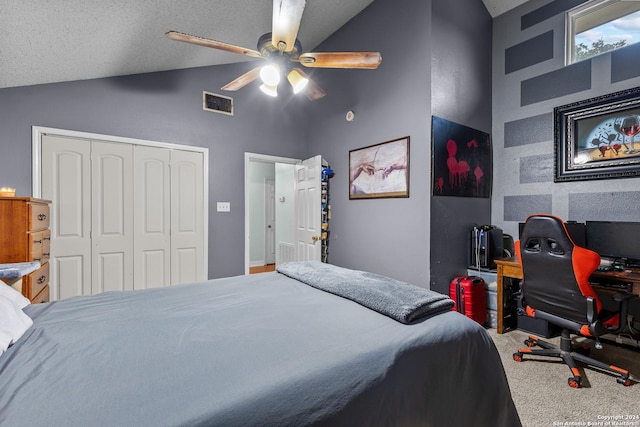 carpeted bedroom with a textured ceiling, a closet, vaulted ceiling, and ceiling fan