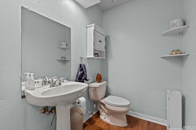 bathroom featuring hardwood / wood-style floors, a textured ceiling, and toilet