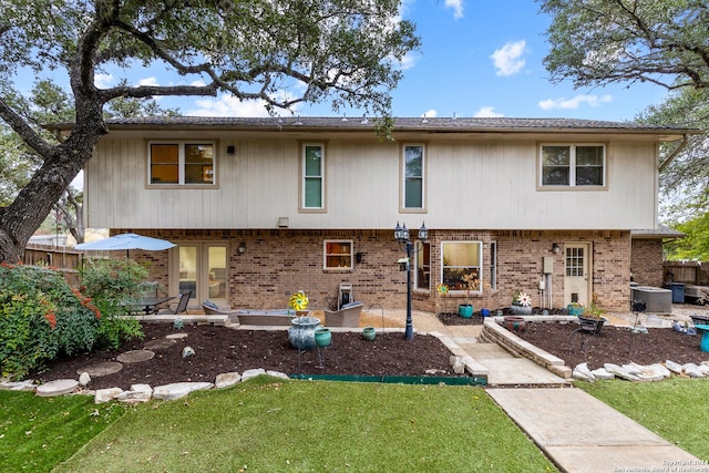 back of house with cooling unit, a patio area, and a lawn