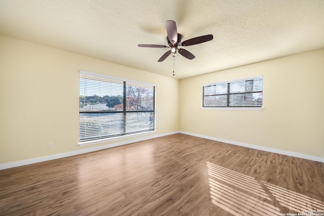 spare room with hardwood / wood-style floors, ceiling fan, and a textured ceiling