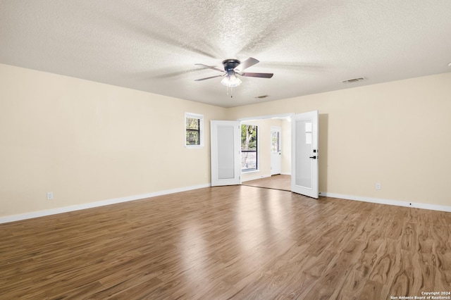 spare room featuring ceiling fan, wood-type flooring, and a textured ceiling