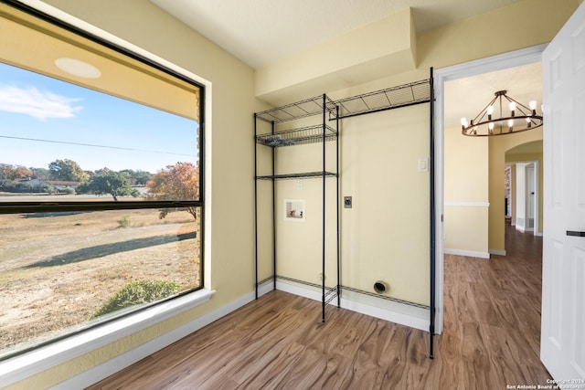 laundry room featuring hookup for a washing machine, a wealth of natural light, electric dryer hookup, and hardwood / wood-style floors