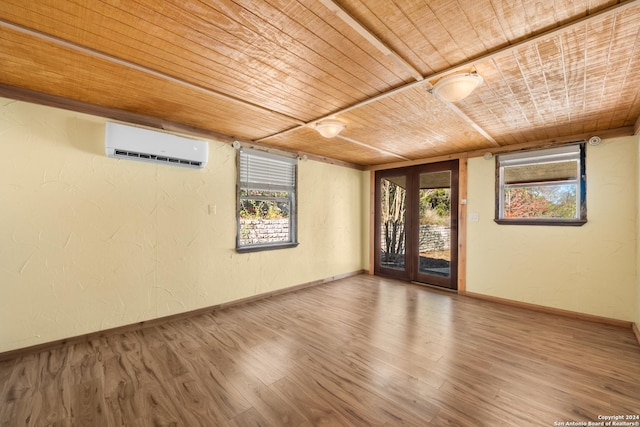 spare room featuring a wealth of natural light, hardwood / wood-style floors, wooden ceiling, and a wall mounted air conditioner