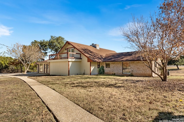 view of front of home featuring a balcony and a front lawn