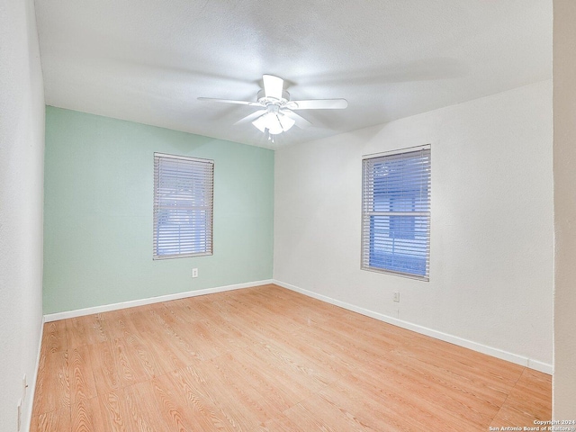 spare room featuring ceiling fan, light hardwood / wood-style floors, and a textured ceiling