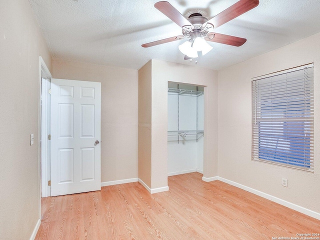 unfurnished bedroom with ceiling fan, light hardwood / wood-style floors, a textured ceiling, and a closet