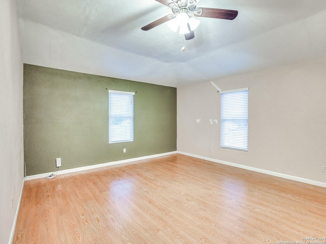 empty room featuring ceiling fan, light hardwood / wood-style floors, and lofted ceiling