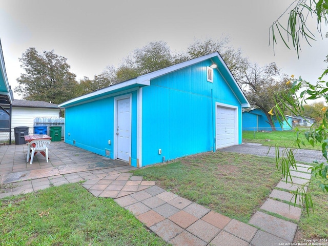 view of outbuilding featuring a lawn and a garage