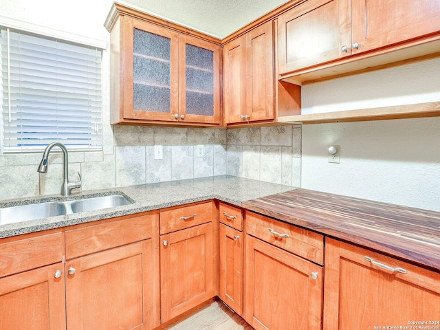 kitchen featuring decorative backsplash, a textured ceiling, and sink