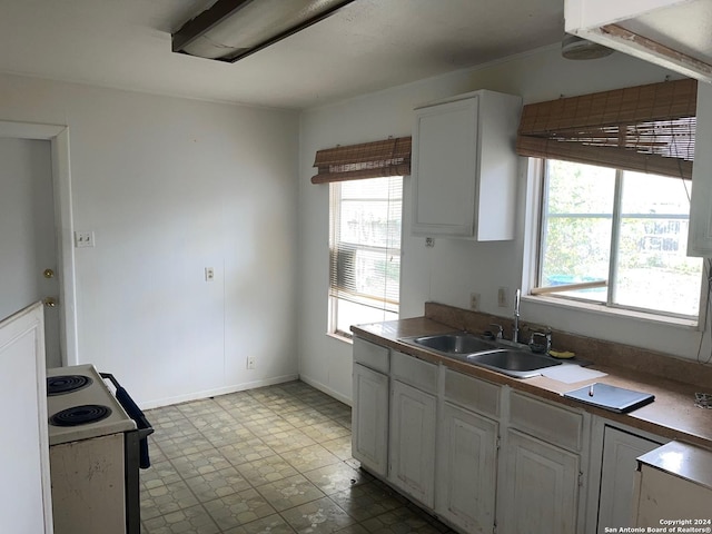 kitchen with white range with electric stovetop, a wealth of natural light, white cabinetry, and sink