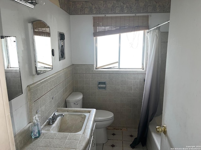 full bathroom with vanity, tile patterned flooring, toilet, tile walls, and shower / tub combo