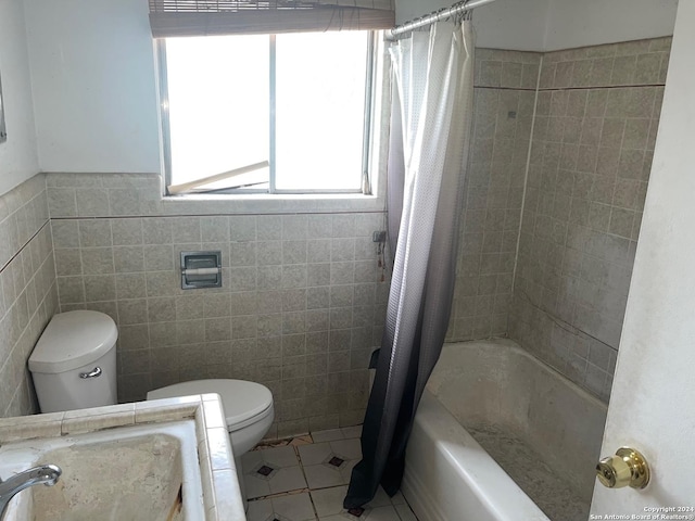 bathroom with tile patterned flooring, toilet, tile walls, and shower / tub combo