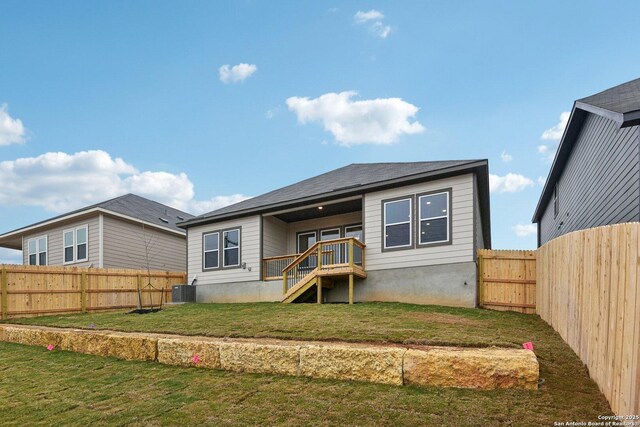 back of property featuring a yard and central AC