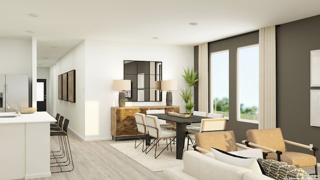 dining space with light wood-type flooring and sink