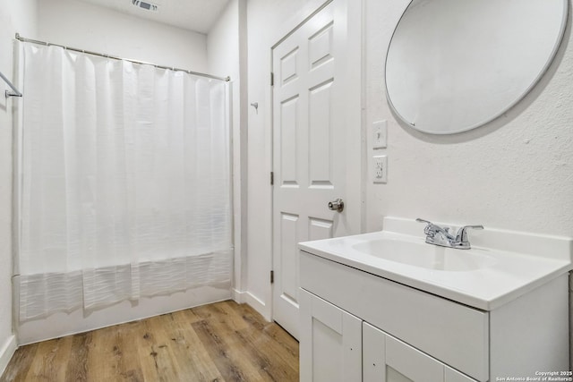 1206 W Hein Rd, San Antonio, TX 78220 - full bath featuring wood finished floors, visible vents, vanity, baseboards, and shower / tub combo