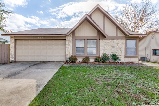 view of front of property with a garage, a front yard, and central AC