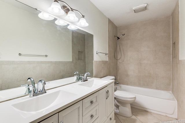 full bathroom with a textured ceiling, tile patterned flooring, tile walls, and tiled shower / bath