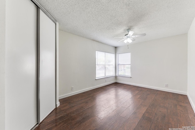 unfurnished bedroom with a textured ceiling, dark hardwood / wood-style flooring, and ceiling fan