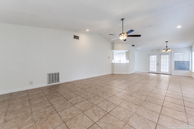 unfurnished room featuring french doors, a textured ceiling, vaulted ceiling, light tile patterned floors, and ceiling fan with notable chandelier