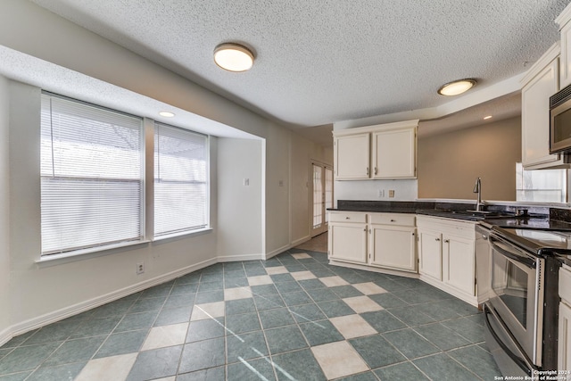 kitchen with a textured ceiling, sink, white cabinets, and stainless steel appliances