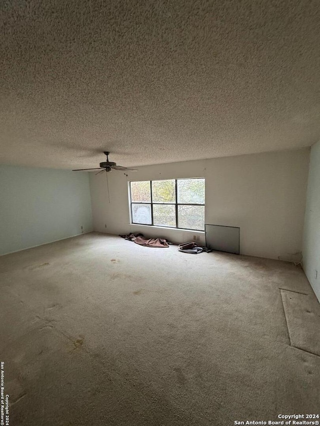 carpeted empty room featuring a textured ceiling and ceiling fan