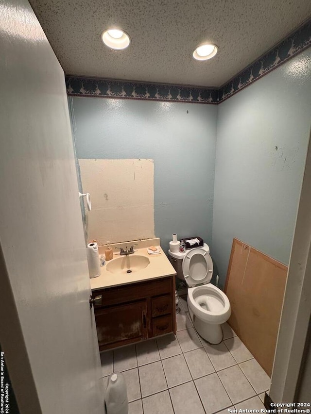 bathroom with tile patterned flooring, vanity, and toilet