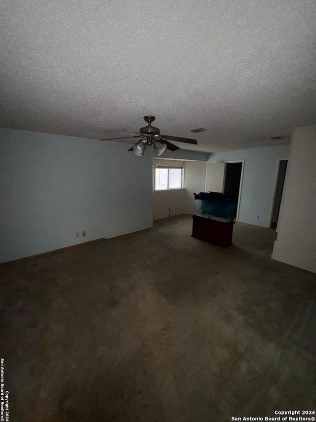 unfurnished living room featuring carpet flooring and a textured ceiling