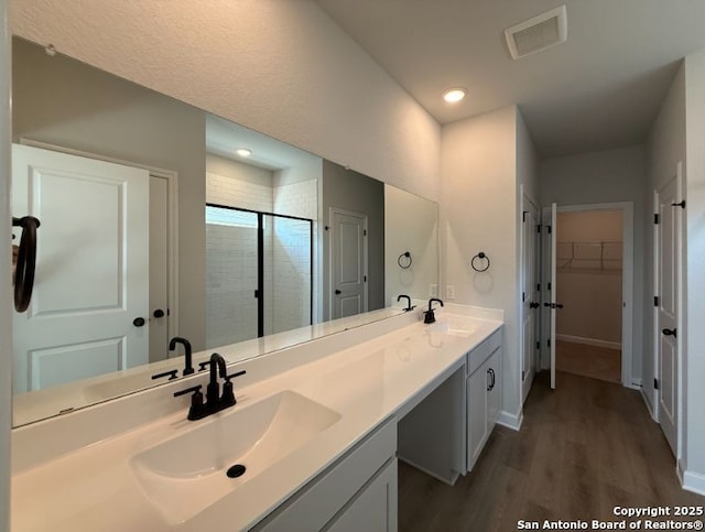 bathroom featuring vanity, hardwood / wood-style flooring, and a shower with door