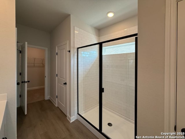 bathroom featuring hardwood / wood-style floors and a shower with door