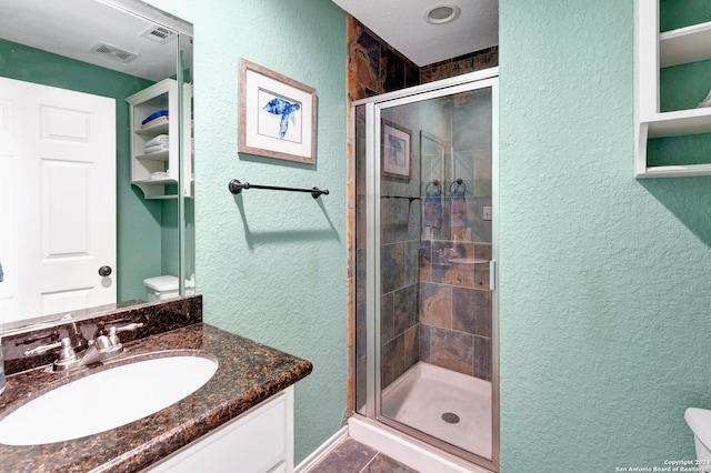 bathroom with vanity, toilet, and a shower with door