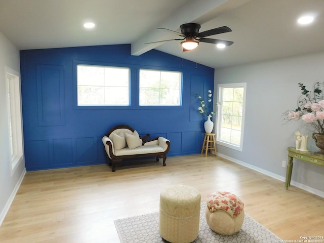 living area featuring ceiling fan, lofted ceiling with beams, and light wood-type flooring