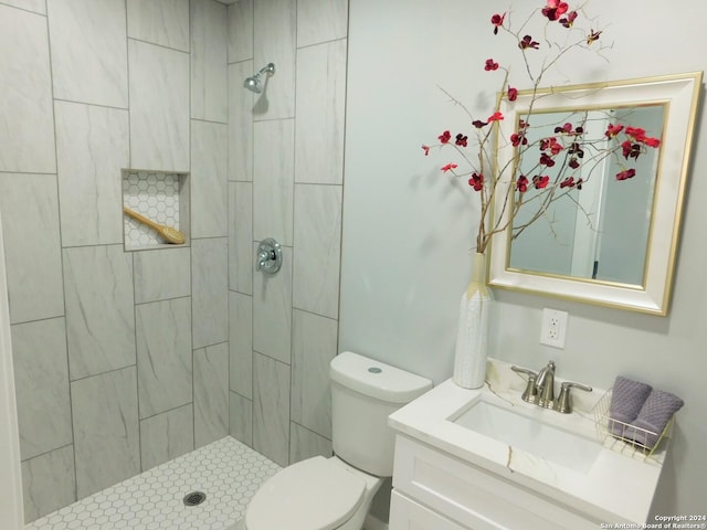 bathroom featuring vanity, toilet, and a tile shower