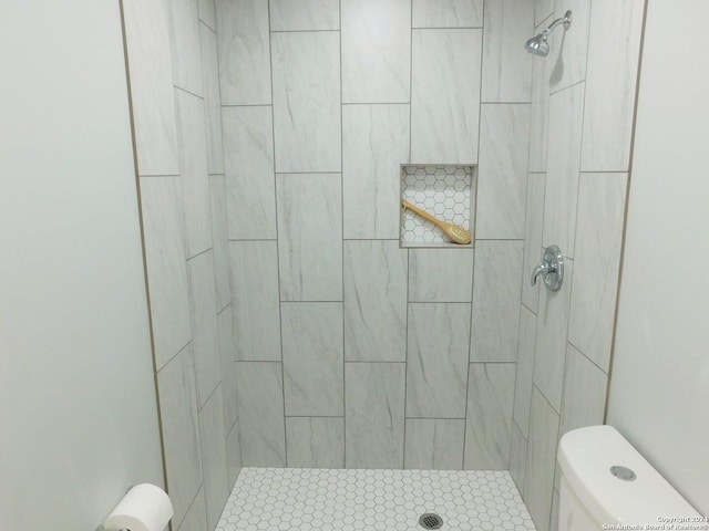 bathroom with toilet and a tile shower