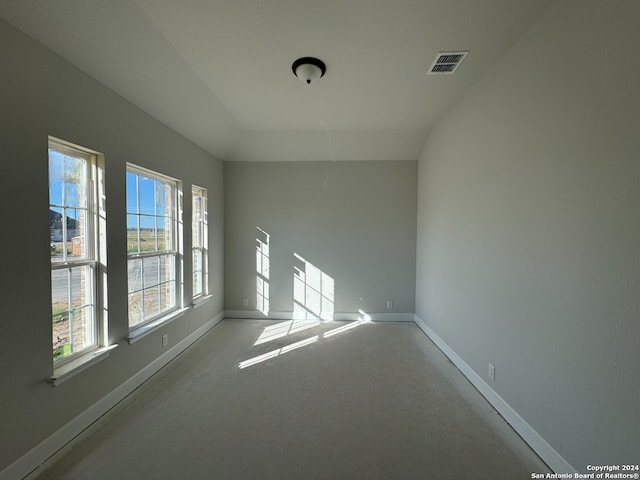 carpeted spare room featuring lofted ceiling