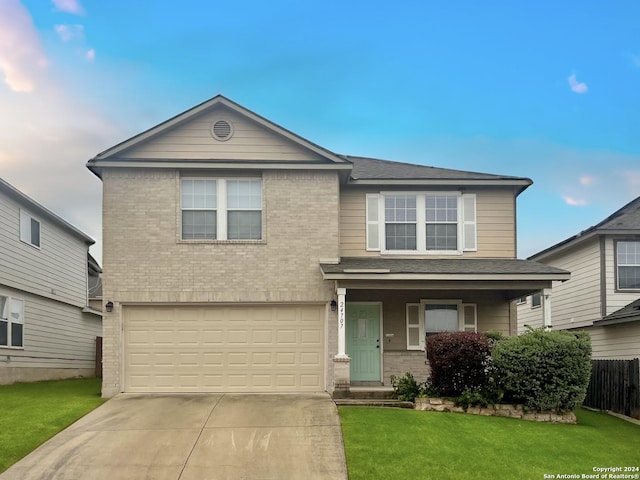 view of property featuring a garage and a front lawn