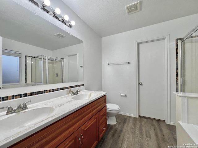 bathroom featuring tasteful backsplash, a textured ceiling, a shower with door, vanity, and hardwood / wood-style flooring