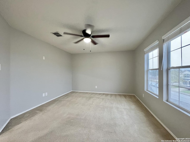 carpeted empty room featuring ceiling fan