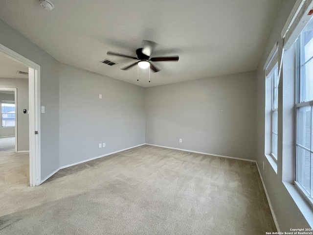 carpeted spare room featuring ceiling fan