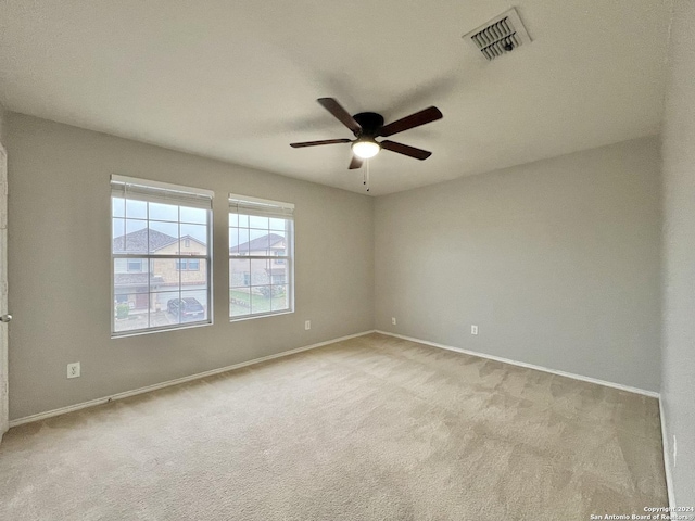 empty room featuring ceiling fan and light colored carpet