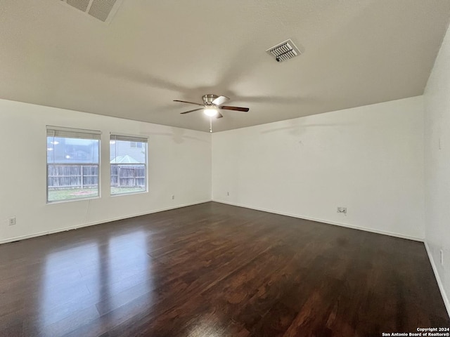 spare room with dark hardwood / wood-style flooring and ceiling fan