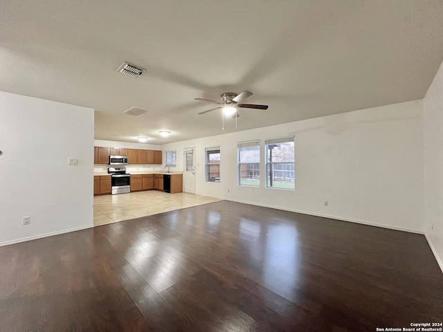 unfurnished living room with light hardwood / wood-style flooring, ceiling fan, and sink