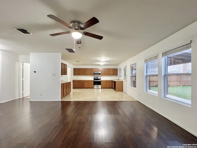 unfurnished living room featuring ceiling fan, light hardwood / wood-style flooring, and sink