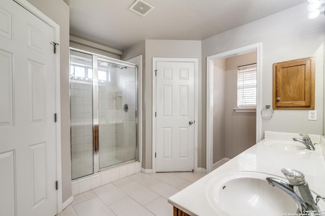 bathroom featuring tile patterned flooring, vanity, an enclosed shower, and a textured ceiling