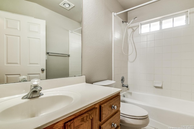 full bathroom with tiled shower / bath, vanity, and toilet