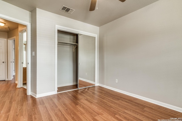 unfurnished bedroom with ceiling fan, a closet, and light wood-type flooring