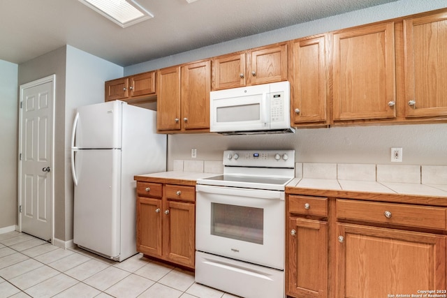 kitchen with white appliances and light tile patterned floors