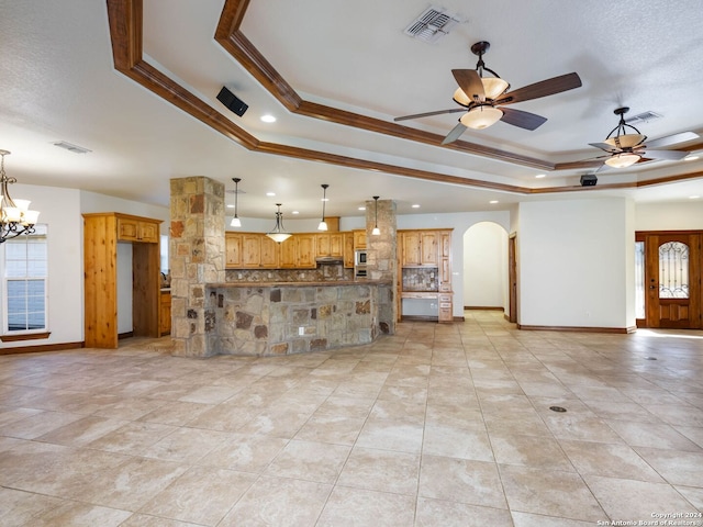 unfurnished living room with a healthy amount of sunlight, crown molding, and a tray ceiling