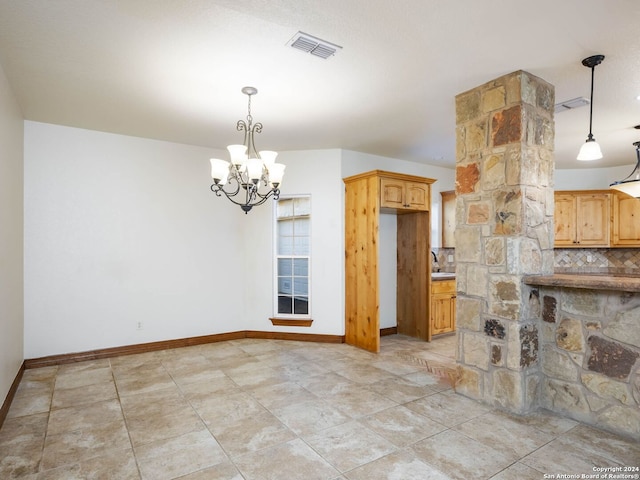 kitchen featuring decorative light fixtures, tasteful backsplash, and a chandelier